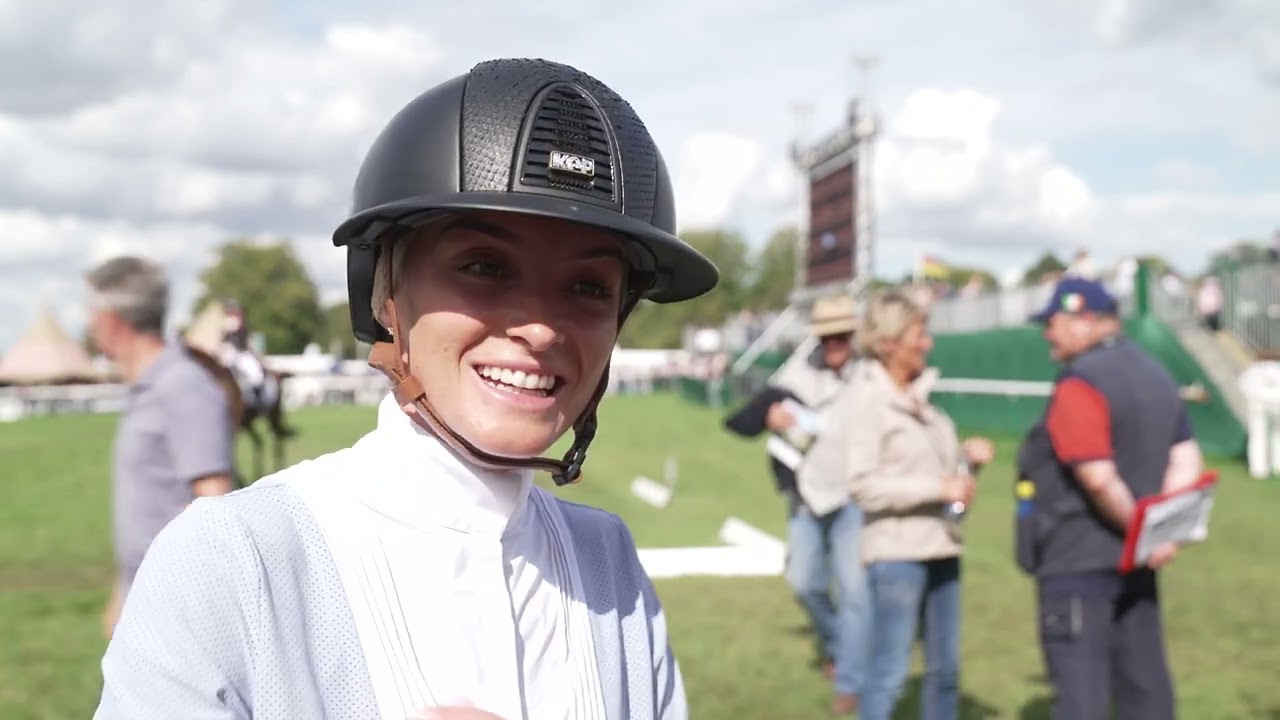 Emily King thrilled with her horse in an atmospheric dressage arena