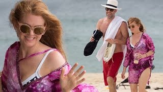 Barefoot beauty! Beaming Isla Fisher dons colourful kaftan over a polka dot bikini at Bondi Beach wi