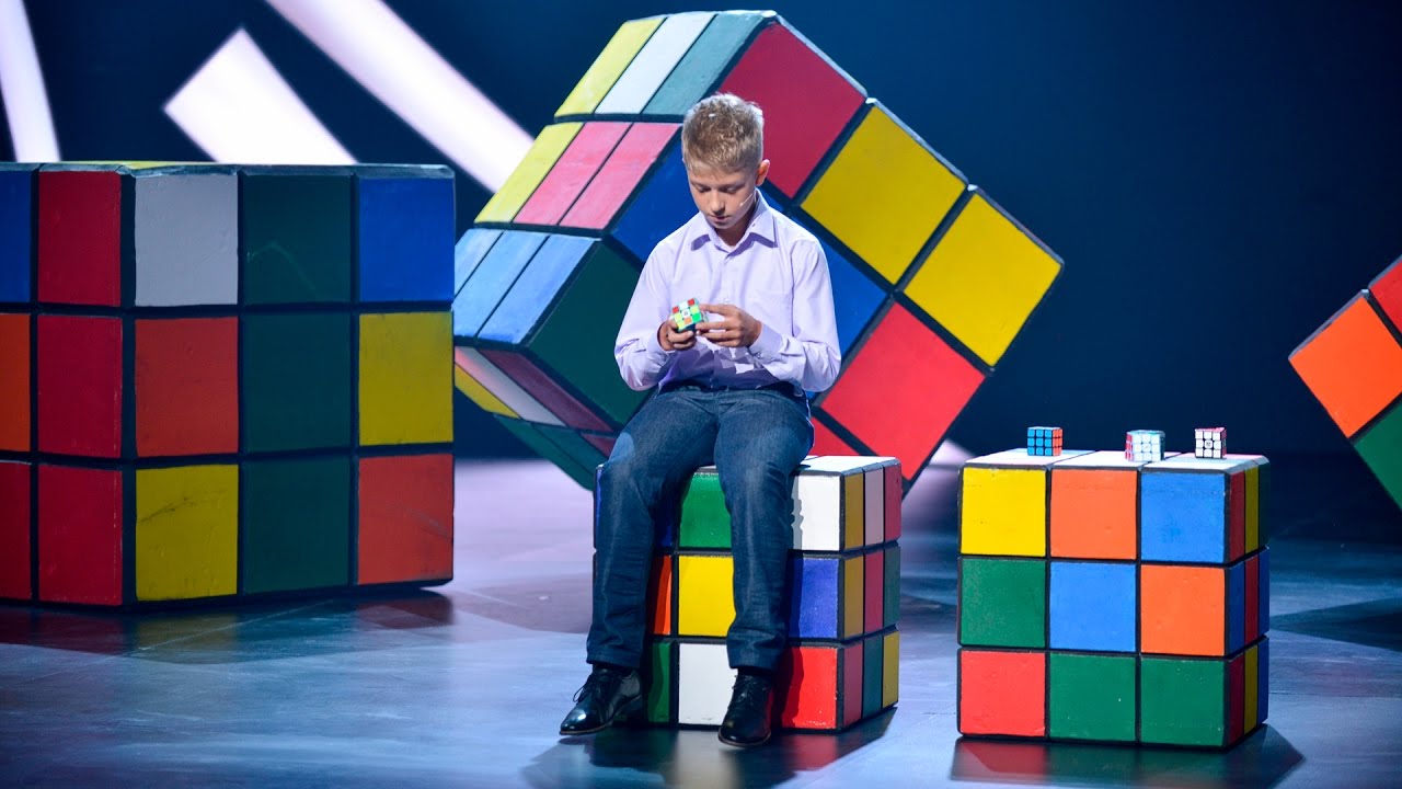 Удивительные люди во сколько. Мужчина собирает кубик Рубика.