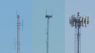 A guyed tower with new LED beacons under its top antenna rack and two other towers Guía