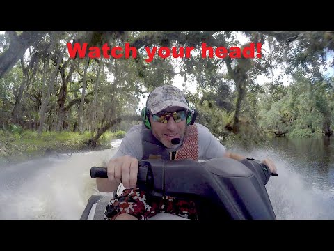 Jet ski under low hanging tree branches on flooded Econ River