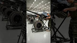 Witness the scale of aviation armament prep as soldiers load massive ammo drums into heavy-caliber