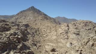 Aerial pan up of plateau to blacken peak of Mount Sinai (Jabal Maqla)