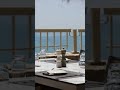 A table set at the edge of the sea.  Dinner begins as the sky turns gold, featuring flavours shaped