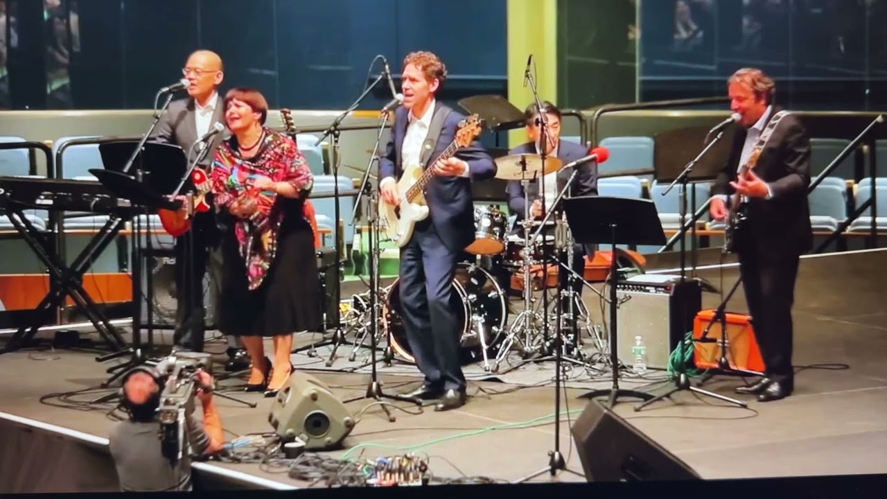 UNRocks performs a cover of “Rockin’ All Over the World” in the UN General Assembly Hall (2015)