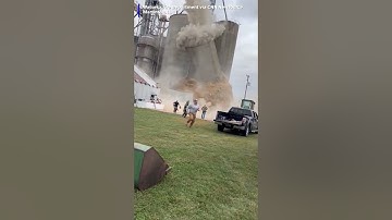 workers running as a grain bin elevator collapsed
