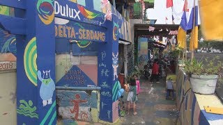 アジア大会に染まる集落の壁 住民彩り、盛り上げ
