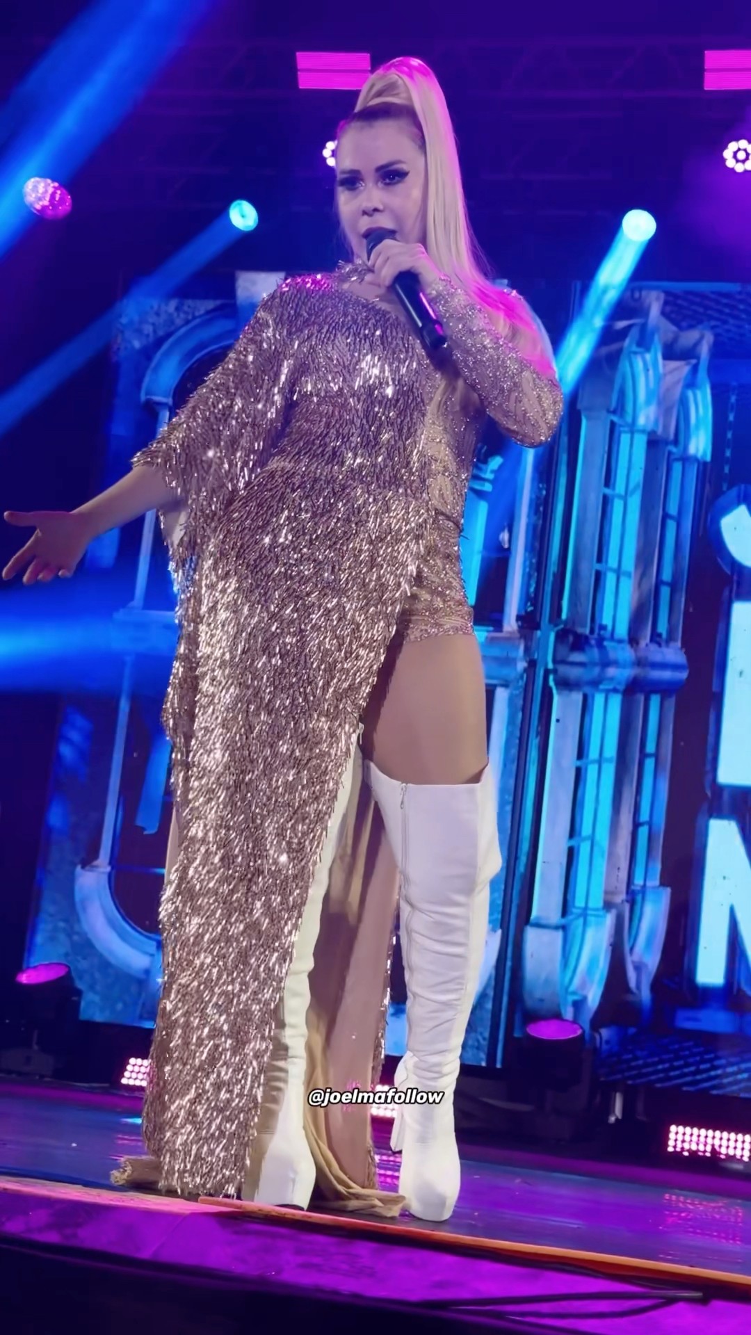 Joelma usa vestido dourado com botas brancas gigantes