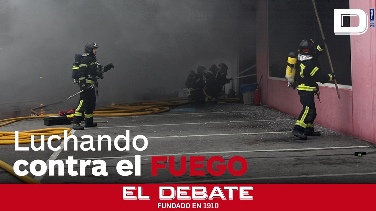 Quince dotaciones de bomberos trabajan para apagar un incendio en una nave en Madrid