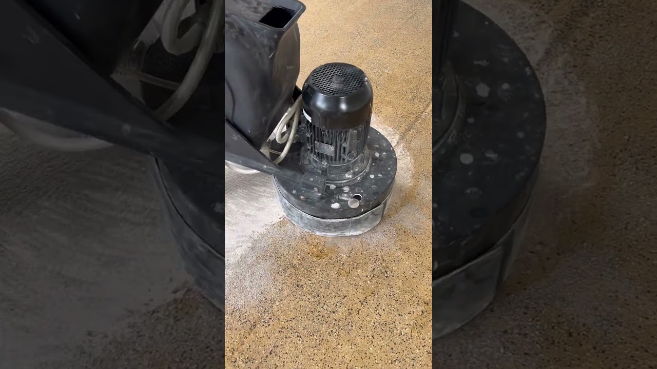 Grinding off the old concrete coating, prepping it for new Polly flake system.