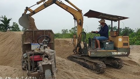 Máy xúc múc vật liệu lên công nông thùng một khối