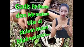 Perempuan berburu dan memakan ular di dalam hutan