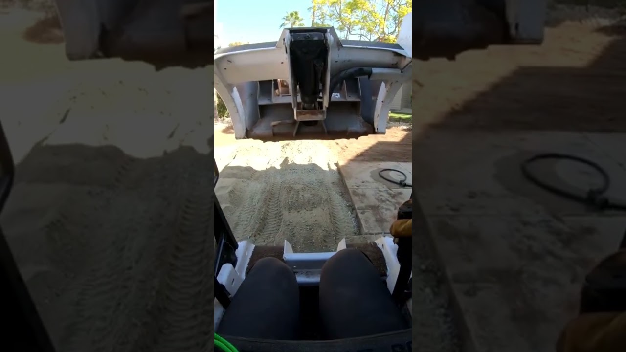 POV driving a mini Bobcat 453 spreading road base for turf install 