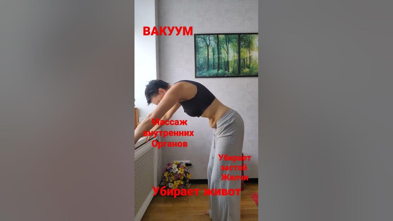 Женщина на берегу реки делает вакуум живота