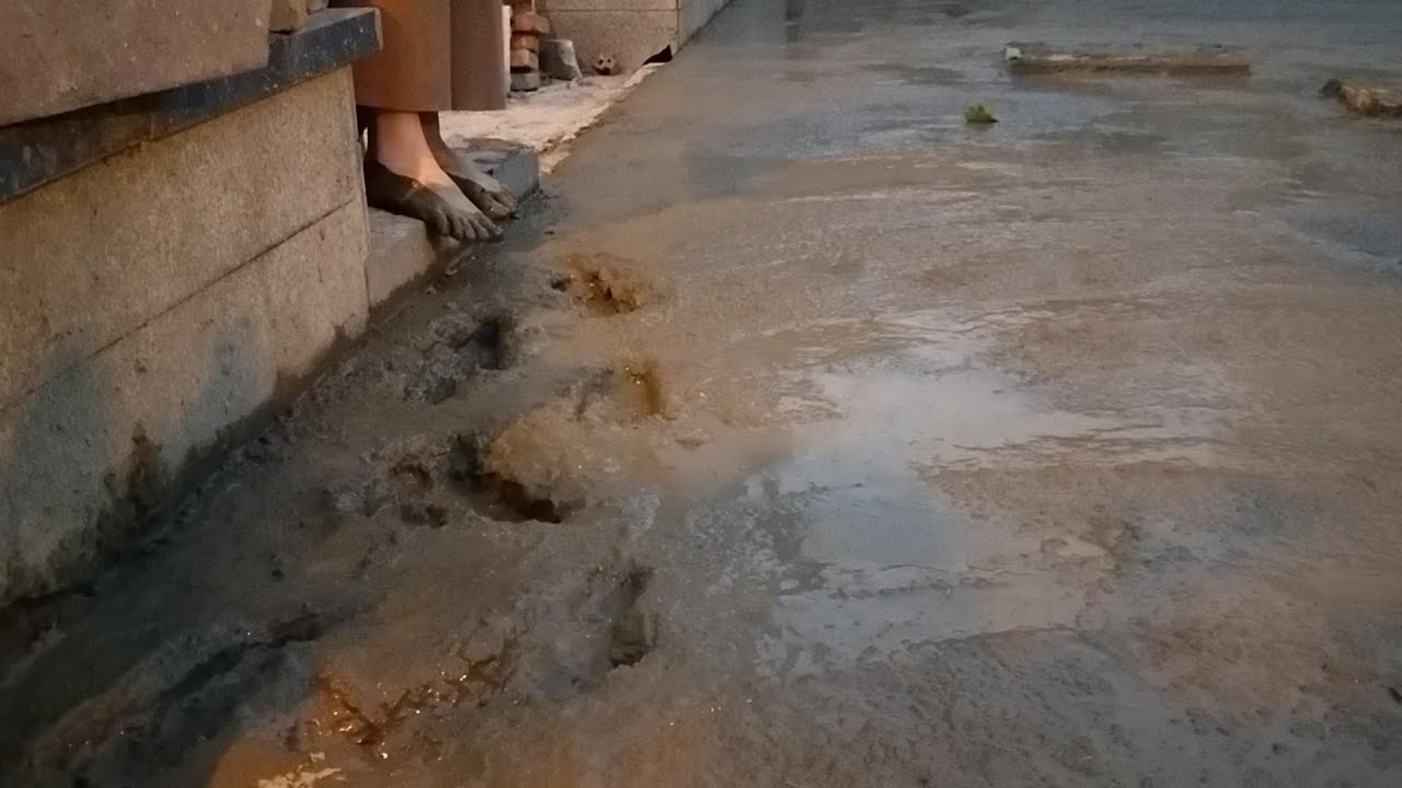 Mici stepped barefoot into the deep mud, and the wet mud soaked her feet