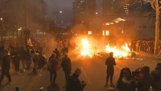 French protesters set dumpsters on fire during march against pension reform | AFP