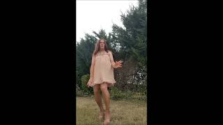Crossdresser smoking in heels and pleated dress
