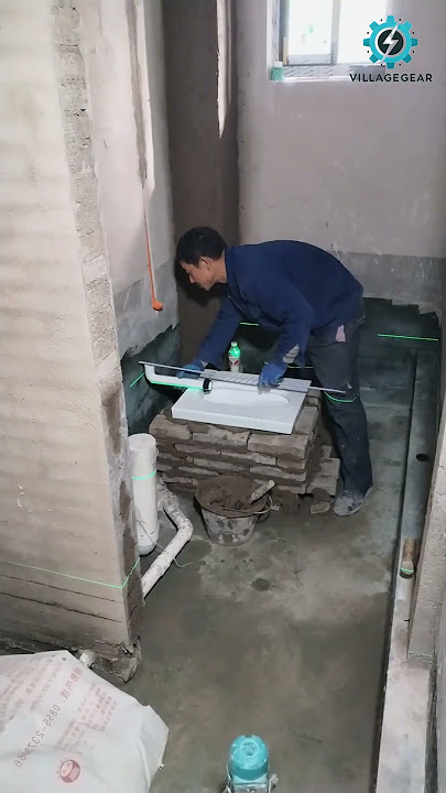 Pekerja renovasi ini sedang memasang toilet jongkok