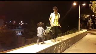 Guy dances with little girl on ledge then she falls off expecting him to catch her