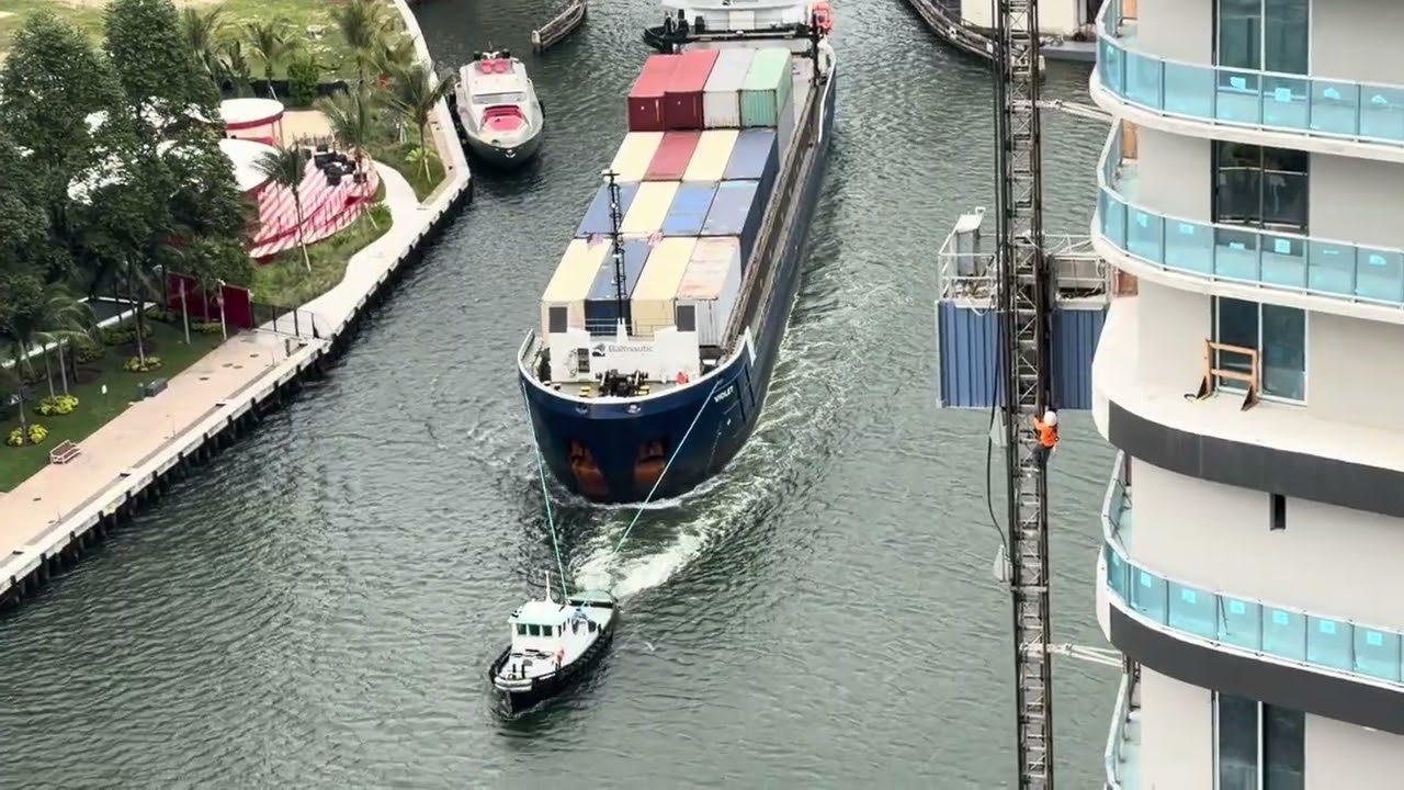 Tugboats Bringing Cargo Ship Into The Miami River 