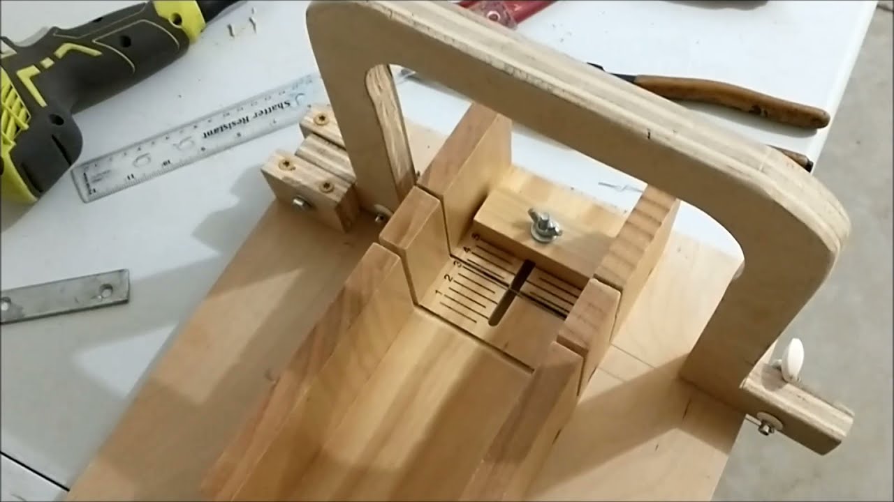 A lady cutting a loaf of soap with a piano wire soap cutter Stock