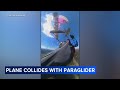 Video shows the terrifying moment a paraglider was struck by a plane.