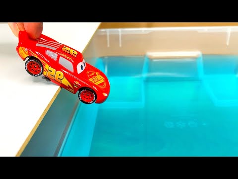 A Lots Of Small Diecast Cars Sliding Into The Blue Water