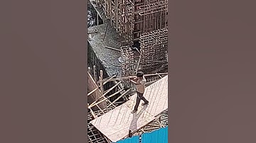 Worker carrying iron bars at construction site #construction #workers #ironbars #carrying #highrise