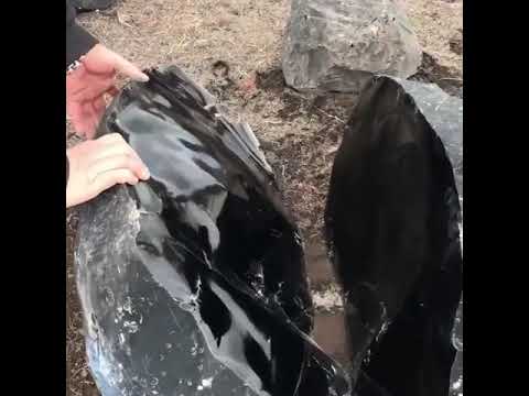 An Obsidian stone split in half. Obsidian is a natural volcanic glass