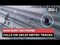 Man busy looking mobile phone falls on rail tracks, CCTV footage