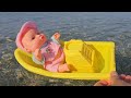 Baby doll playing and swimming on the beach