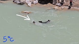 A strange nomad carrying a horse across a very cold river