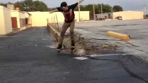 Skateboarding Ollie over parking block and gap