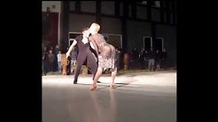 A couple performing a ballroom dance on the street.