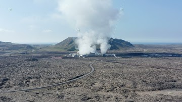 Aerial view flying over a geothermal power plant in Iceland. Drone View over power station producing
