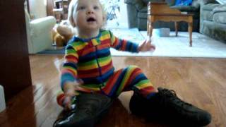 Aliz wearing Tata's papucs and waiving tai-tai (14mo, May 2011)