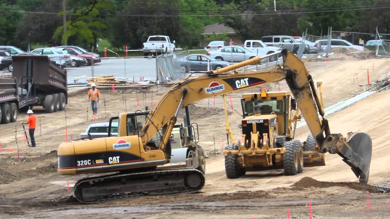 CAT 320C Excavator moving and digging dirt with dump truck dumping in ...