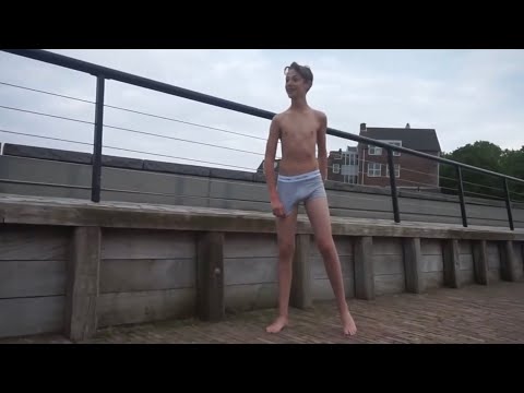 Lange jongen staat in grijze Calvin Klein onderbroek op de kade