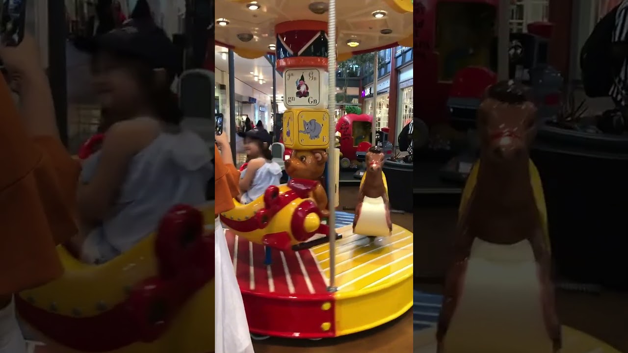 Child having fun on a mall carousel