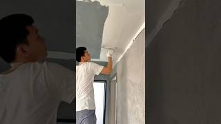 Worker Applying Plaster Smoothly on Ceiling Surface for Interior Finishing