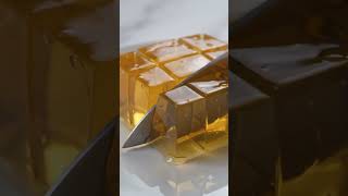 a giant mango jelly cube being cut into tiny perfect squares.