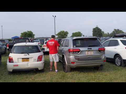 Man peeing between cars