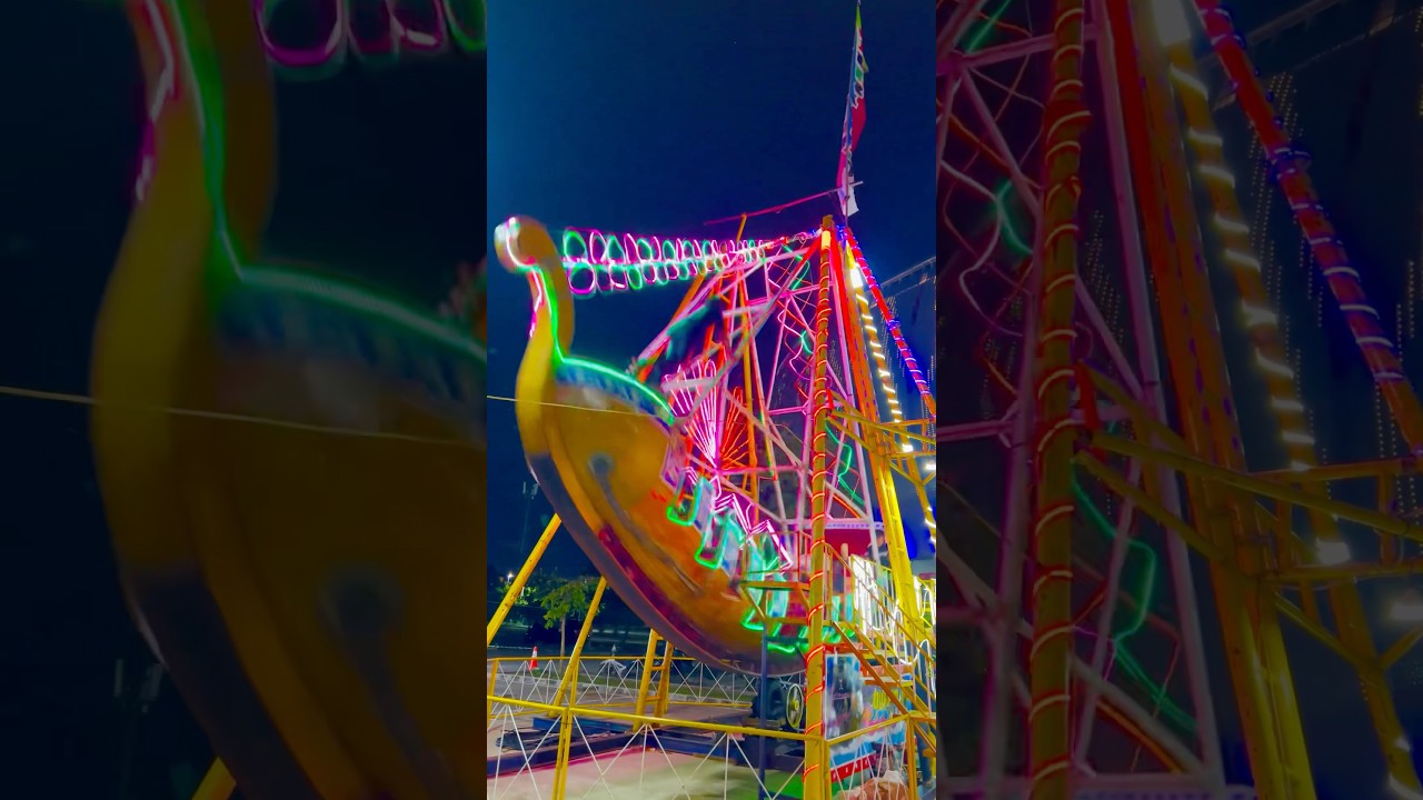 🎡✨ Wooden pirate ship ride glowing with colorful lights at the night fair!