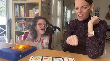 Angela and Mom playing woth a toy and using PODD to chat about it.