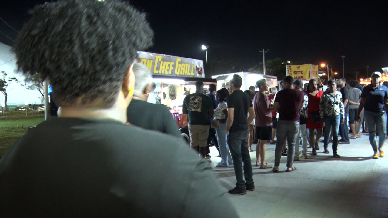 Продавцы и посетители отмечают открытие Flava Village в парке Queen's Park Savannah.