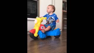 10 month old baby sitting on toy bike with music