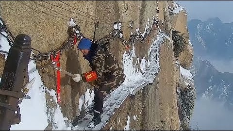 Workers Clear Snow on Dangerous Cliff