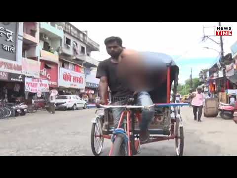A cycle rickshaw driver Rajesh rides across the city carrying his younger son on his shoulder in MP