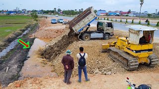 Fast filling land up into the water to height similar road by KOMATSU D31P dozer with dump trucks