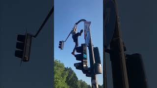Traffic Light Climber Startles Crowd at an Event